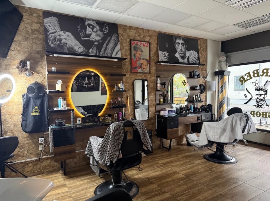Salongens interiör med träpaneler, stenvägg, upplysta speglar och två barberarstolar